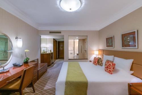 a hotel room with a large bed and a desk at Okura Garden Hotel Shanghai in Shanghai