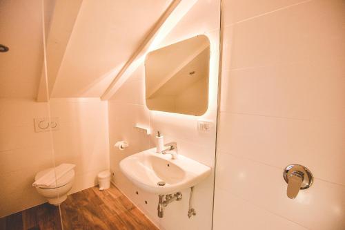 a white bathroom with a sink and a toilet at Old Town Inn in Rijeka