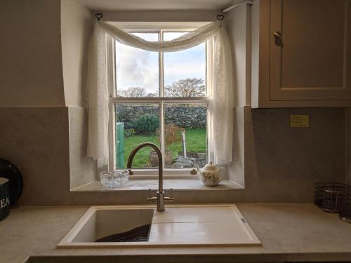 a kitchen with a sink and a window at Rose Cottage in Ulverston