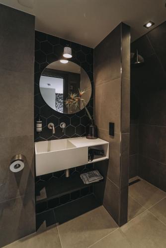 a bathroom with a sink and a mirror at Hotel Bell in Zandvoort