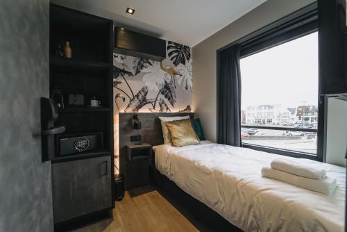 a bedroom with a bed and a large window at Hotel Bell in Zandvoort