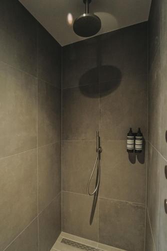a bathroom with a shower with a shower head at Hotel Bell in Zandvoort