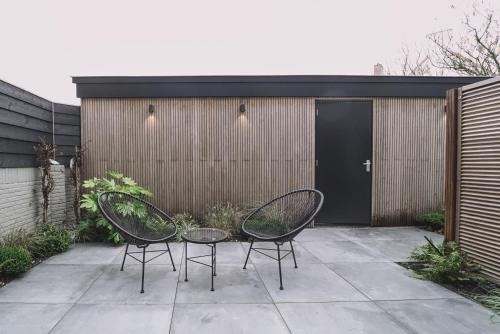 two chairs and a table on a patio at Hotel Bell in Zandvoort