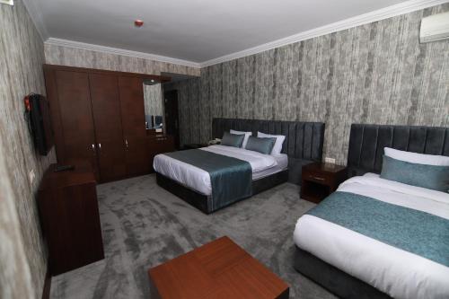 Bostaniçi的住宿－SARDUR HOTEL，酒店客房设有两张床和一张桌子。