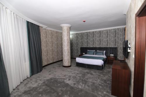 a hotel room with a bed and a column at SARDUR HOTEL in Bostaniçi