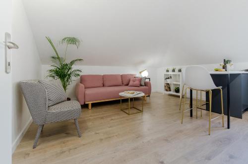 a living room with a pink couch and two chairs at Inn by the River in Omiš