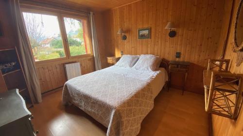 une chambre avec un lit avec des draps blancs et une fenêtre dans l'établissement Chalet Baraka Vue MontBlanc, à Chamonix-Mont-Blanc