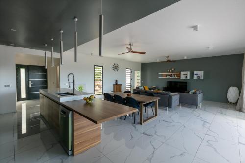 uma cozinha e sala de estar com uma mesa e um sofá em Vini Villa Bora em Bora Bora