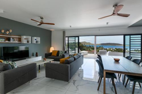 sala de estar con sofá, mesa y sillas en Vini Villa Bora en Bora Bora