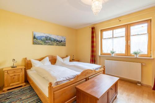 a bedroom with a bed and a table and a window at Allgäuglück in Sonthofen