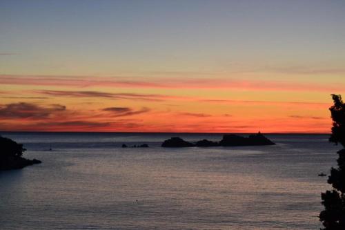 a sunset over the ocean with rocks in the water at Art Hotel Dubrovnik in Dubrovnik