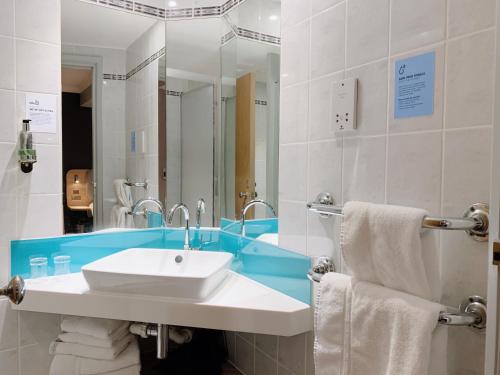 a bathroom with a sink and a mirror at Holiday Inn Express London Victoria, an IHG Hotel in London