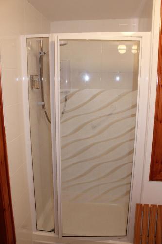 a shower with a glass door in a bathroom at The Barn Lodge in Stirling