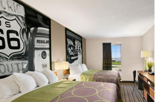 a hotel room with two beds and a football mural at Super 8 by Wyndham Stafford/Springfield Area in Strafford
