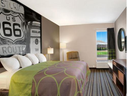 a hotel room with a bed with a football sign on it at Super 8 by Wyndham Stafford/Springfield Area in Strafford