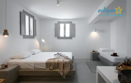 a white bedroom with a bed and a couch at Antiparos Homes in Antiparos Town