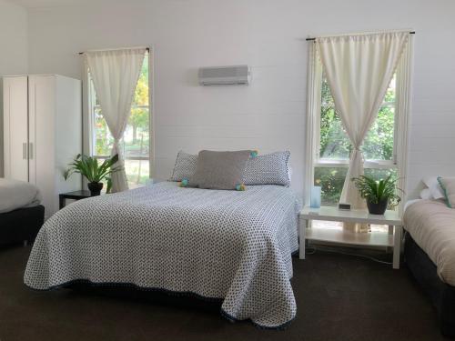 ein Schlafzimmer mit einem Bett und zwei Fenstern in der Unterkunft Cinta Cottage in Loch