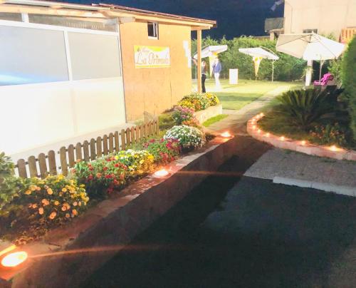 a garden with flowers and lights next to a building at Hotel La Primula in Corigliano Calabro