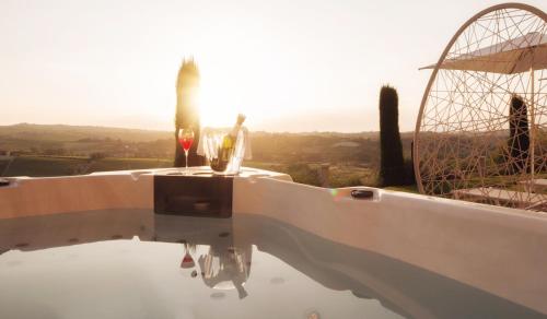 a table with two wine glasses on top of it at Villa Fontana Relais Suite & Spa in Agliano Terme