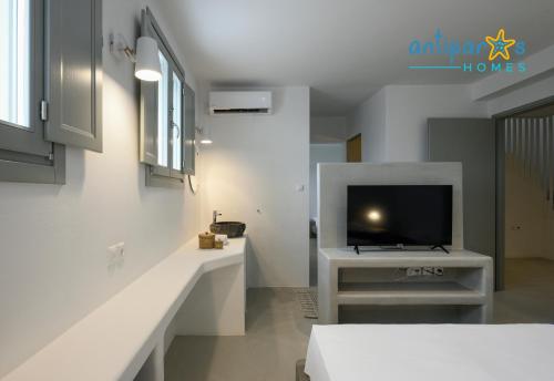 a living room with a tv and a white table at Antiparos Homes in Antiparos Town