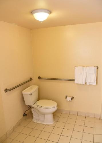 a bathroom with a toilet and towels on the wall at Baymont by Wyndham Columbus GA in Columbus