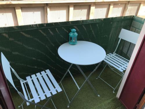 a table and two chairs and a bottle on a table at LES ÎLES - Parking, Balcon & PS4! in Annecy