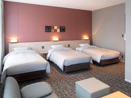 a hotel room with three beds and a couch at Kotohira Park Hotel in Kotohira