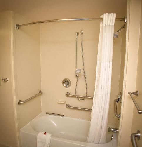 a bathroom with a tub and a shower with a shower curtain at Baymont by Wyndham Columbus GA in Columbus