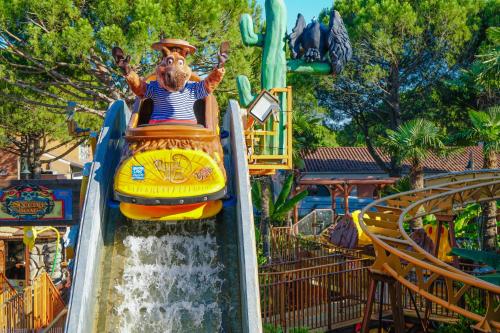 a man riding on a water slide at a water park at Victoria Mobilehome in Union Camping Cavallino in Cavallino-Treporti