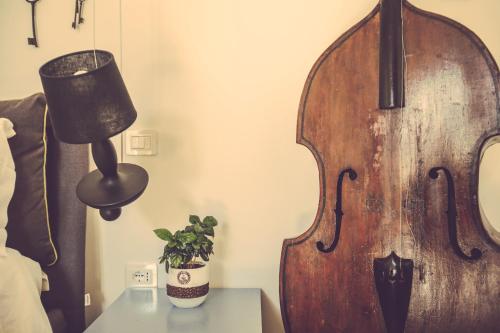 a large violin in a bedroom with a lamp and a plant at Langhe Country House in Neive