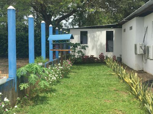 a house with a blue fence and a yard at Hotel campestre la Maria in Villavicencio
