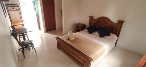 a bedroom with a large bed and a chair at Hotel campestre la Maria in Villavicencio