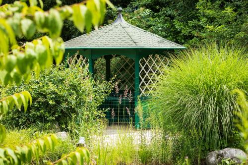 a gazebo in the middle of a garden at Vitalhotel Marienhof in Velden am Wörthersee