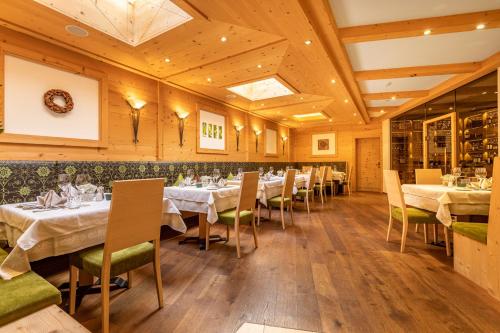 a dining room with white tables and chairs at Kräuterhotel Hochzillertal 3 Sterne Superior in Kaltenbach