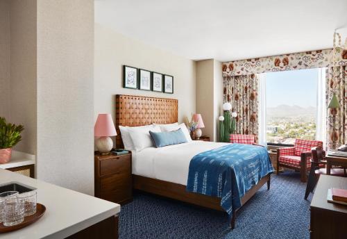 a hotel room with a bed and a large window at Graduate by Hilton Tucson in Tucson