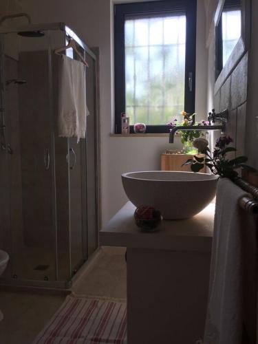 a bathroom with a sink and a glass shower at Chateaux des Trulli in San Michele Salentino