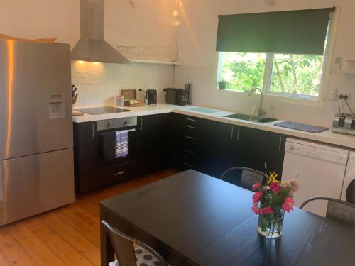 a kitchen with a table with a vase of flowers on it at Cinta Cottage in Loch