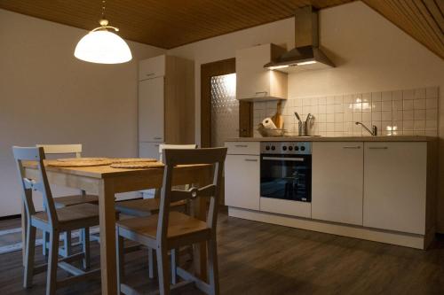 a kitchen with a table and chairs and a stove at Schöne Ferienwohnung in Kürten in Kürten