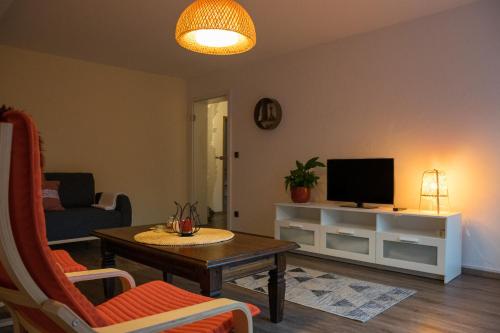 a living room with a table and a tv at Schöne Ferienwohnung in Kürten in Kürten