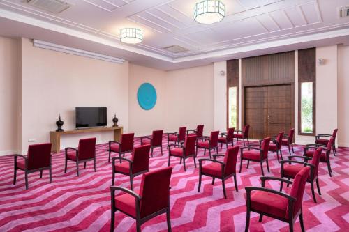 a room with red chairs and a flat screen tv at Hillstone Bodrum Hotel & Spa in Bodrum City
