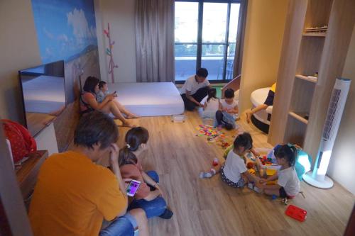 grupa dzieci siedzących na podłodze w pokoju w obiekcie 綠竹弄親子民宿附設背包客房 w mieście Ch'i-she