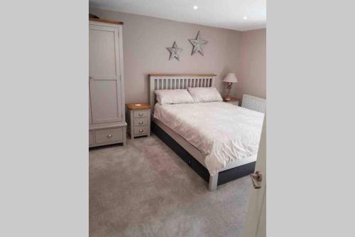 a bedroom with a bed and two stars on the wall at Beautiful Cottage in Central St Columb Major in Saint Columb Major