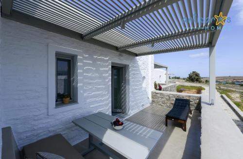 a patio with a pergola and a table and chairs at Antiparos Homes in Antiparos Town