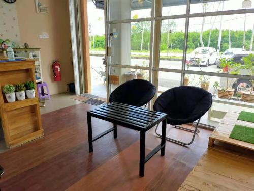 Duas cadeiras e uma mesa de centro num quarto com uma janela em CSH Motel em Kangar