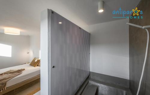 a small bedroom with a bed and a wall at Antiparos Homes in Antiparos Town