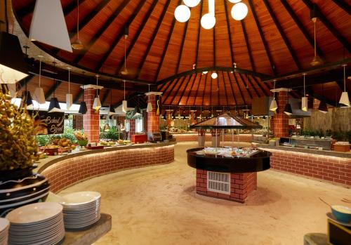 a restaurant with a food counter in the middle at Sun Siyam Iru Fushi with Free Transfer in Manadhoo