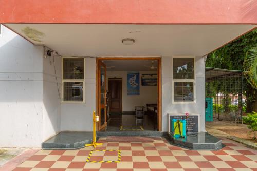 an open door to a building with a checkered floor at KSTDC Hotel Mayura Velapuri Belur in Belūr