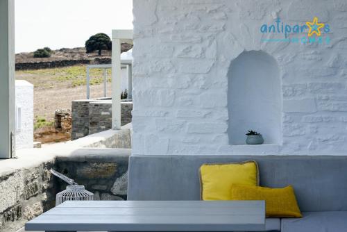 a yellow pillow sitting on a bench next to a wall at Antiparos Homes in Antiparos Town