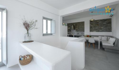 a white kitchen and living room with a vase on the counter at Antiparos Homes in Antiparos Town
