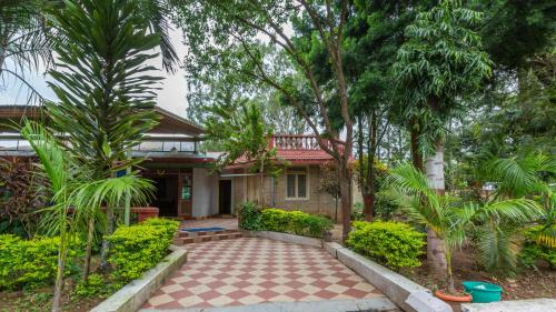 uma casa com um pátio em frente em KSTDC Hotel Mayura Velapuri Belur em Belūr